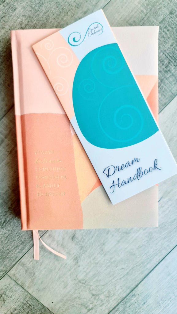 Dream Handbook pamphlet overtop of peach coloured journal
